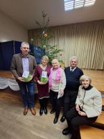 foto: na tle choinki od lewej stoją Wójt Gminy Bartłomiej Strózik, Sekretarz Gminy Jadwiga Generowicz, troje seniorów